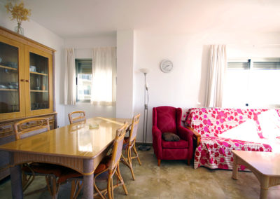 Comedor con mesa de madera y salón con sofá